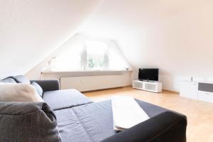 a living room with a couch and a tv at Schönebeck Apartment in Essen