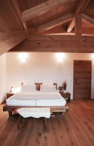 uma cama grande num quarto com tectos em madeira em ENTSPANNUNG AM SELTENHOF em Rosenheim