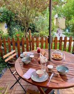 a wooden table with plates of food on it at Maison du bonheur in Villiers-sur-Marne