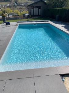 Una piscina con agua azul en un patio. en La Roséa, en Mende