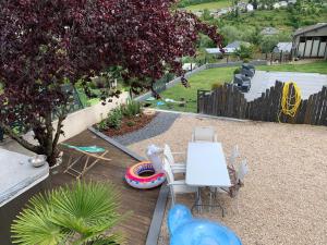 un patio trasero con mesa, sillas y parque infantil en La Roséa, en Mende