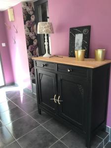 a black cabinet with a wooden top in a room at La Roséa in Mende