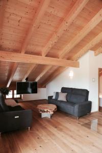 ein Wohnzimmer mit 2 Sofas und einem Flachbild-TV in der Unterkunft ENTSPANNUNG AM SELTENHOF in Rosenheim