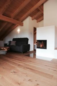 a living room with a black couch and a fireplace at ENTSPANNUNG AM SELTENHOF in Rosenheim