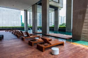 a lobby with chairs and a pool in a building at Arcoris Mont Kiara next 163plaza 1-4Pax one plus one Bedroom in Kuala Lumpur