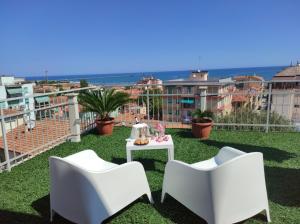 a balcony with two chairs and a table on the grass at LA TERRAZZA in Falconara Marittima