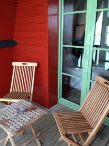 2 chaises assises sur la terrasse couverte d'une maison rouge dans l'établissement Hotel d'Aleth, à Saint-Malo