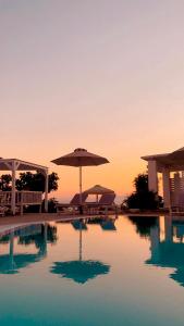 una piscina con ombrellone e tavoli e sedie di Krotiri Bay -adults only a Paroikia
