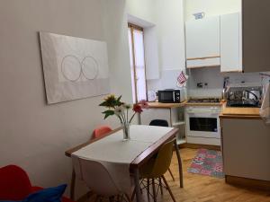 a kitchen with a table with a vase of flowers on it at San Domenico House in Arezzo