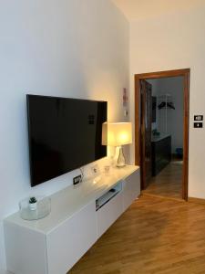 sala de estar con TV de pantalla plana grande en la pared en San Domenico House en Arezzo
