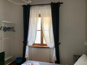 una camera da letto con una finestra con tende e un letto di San Domenico House ad Arezzo