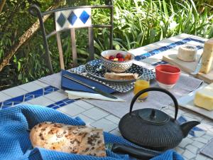 a table with a tea kettle and a plate of food at Le Pré in Juriens