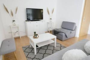 a living room with a tv and a couch and a table at Ferienwohnung Rhode in Rielasingen-Worblingen