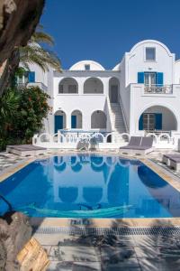a large white house with a swimming pool in front of it at Pension George in Karterados