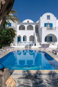 uma grande casa branca com uma piscina em frente em Pension George em Karterados