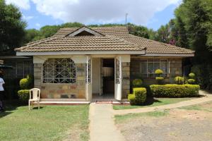 ein kleines Haus mit einer Veranda und einer Tür in der Unterkunft Salient Guest House in Eldoret