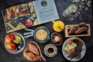 una mesa con platos de desayuno y un libro en Hotel Watles, en Malles Venosta