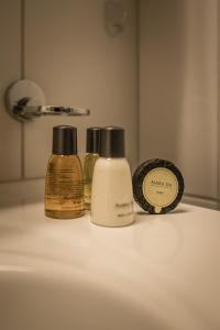 a bathroom sink with three bottles of soap and a mirror at Apartment Trümmelbach, Comfortabl & Cozy, Private Terrace with best views in Lauterbrunnen +32 photos