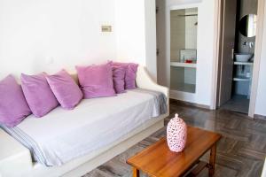 a white couch with purple pillows in a living room at Pension George in Karterados