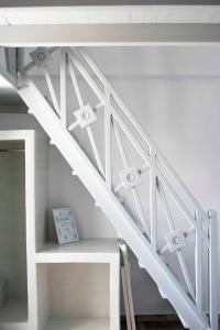 a white staircase with a shelf under it at Pension George in Karterados