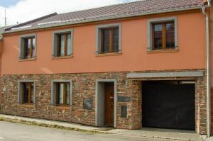 an orange brick building with a garage at Penzion No. 1 in Olomouc