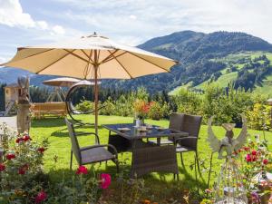 a table and chairs with an umbrella in the grass at Grillinghof in Kirchberg in Tirol