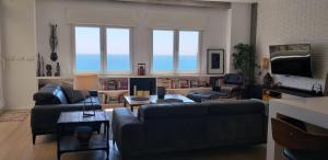 Ático Loft en frente al mar terraza vista espectacular في أليكانتي: غرفة معيشة مع كنبتين وطاولة