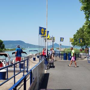 a group of people walking on a pier near the water at Lido Dalma Apartman 2 in Fonyód