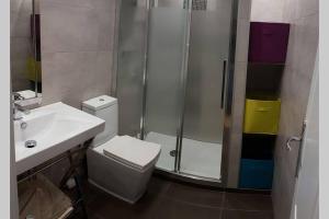 een badkamer met een douche, een toilet en een wastafel bij Acogedor apartamento familiar in Marbella