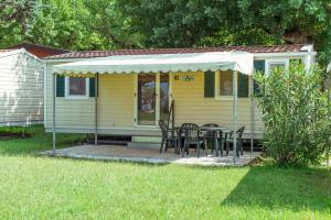 a small yellow house with a table and chairs at Camping Wien in Peschiera del Garda