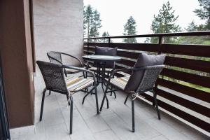 eine Terrasse mit einem Tisch und Stühlen auf dem Balkon in der Unterkunft Apartman Pavle in Zlatibor