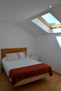 een slaapkamer met een bed en een dakraam bij Cerca da Vitoria 2 Sesimbra in Sesimbra