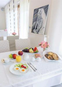 una mesa blanca con platos de comida. en Villa Aina Boutique Hotel en Laško