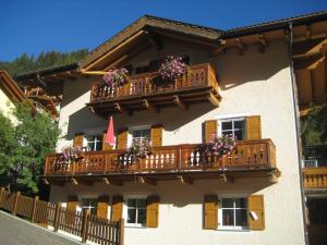 a building with a balcony with flowers on it at Chalet Decrestina in Campitello di Fassa