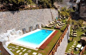 an overhead view of a swimming pool with people sitting around it at Cartiera Apartment with Pool by AMALFIVACATION in Amalfi