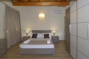 Attico panoramico fronte mare في ليدو دي كامايوري: غرفة نوم بسرير كبير في غرفة بها مصباحين