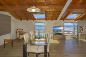 Attico panoramico fronte mare في ليدو دي كامايوري: غرفة طعام مع طاولة وكراسي وتلفزيون