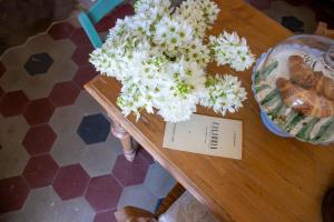 einen Tisch mit weißen Blumen darüber in der Unterkunft Palazzo del Diplomatico in Belmonte Calabro