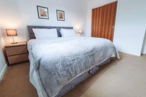 a bedroom with a large bed and two lamps at Hilton Wynd Apartment in Rosyth