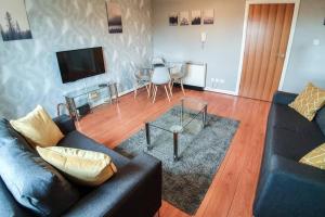 a living room with a couch and a glass table at Hilton Wynd Apartment in Rosyth