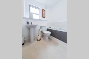 a white bathroom with a sink and a toilet at Hilton Wynd Apartment in Rosyth