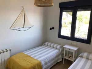 sypialnia z dwoma łóżkami i żaglówką na ścianie w obiekcie Villa Balbina w mieście Bueu