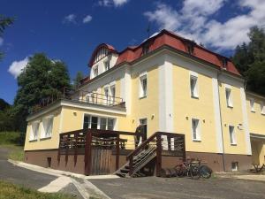 a large yellow building with a red roof at Horská Chata Pod Lanovkou in Jáchymov