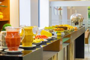 - un buffet avec des boissons et de la nourriture sur une table dans l'établissement Rede Andrade Luxor, à Teresina