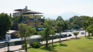 a view of a parking lot with a yellow building at Bülent Kocabaş-Selinus Beach Club Hotel in Gazipasa