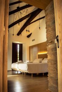 a bedroom with two beds and a stone wall at A Casa da Botica in Samos