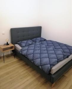 een bed in een kamer met een bijzettafel bij Apartment Leggero in Moravske-Toplice