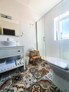 uma casa de banho com uma banheira, um lavatório e um WC. em PÊPA Guesthouse em Setúbal
