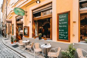 a restaurant with tables and chairs on a street at Hotel Dar in Prague