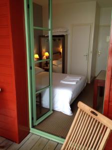 a bedroom with a bed with a mirror and a bench at Hotel d'Aleth in Saint Malo